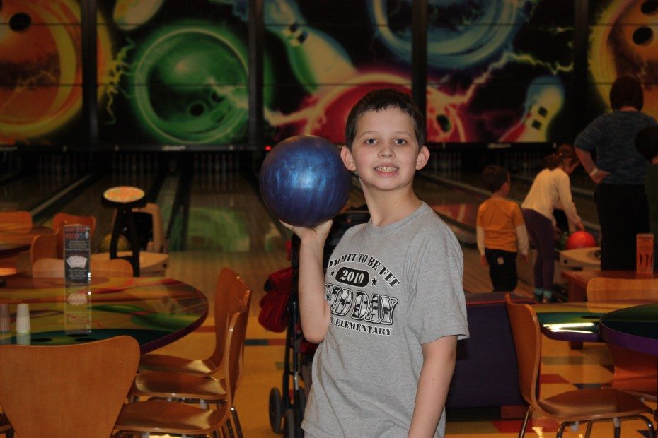 boy holds a bowling ball Kids Bowl Free an bowling alleys near me in New Jersey
