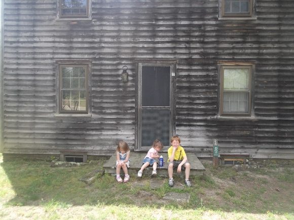 hildren in front of one of the old cottages at Historic Batsto Village