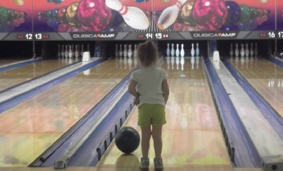 A child stands at a bowling lane at a NJ bowling alleys near me