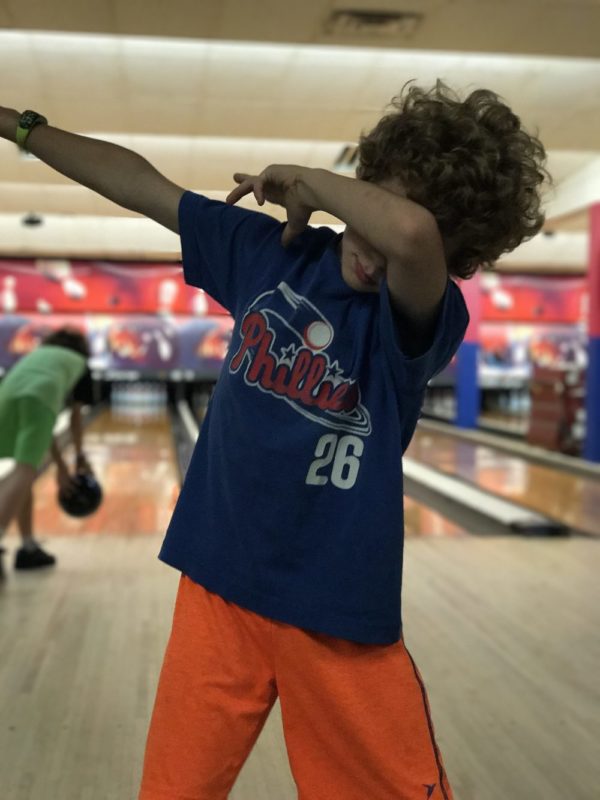 9 year old boy dabbing at bowling alley.