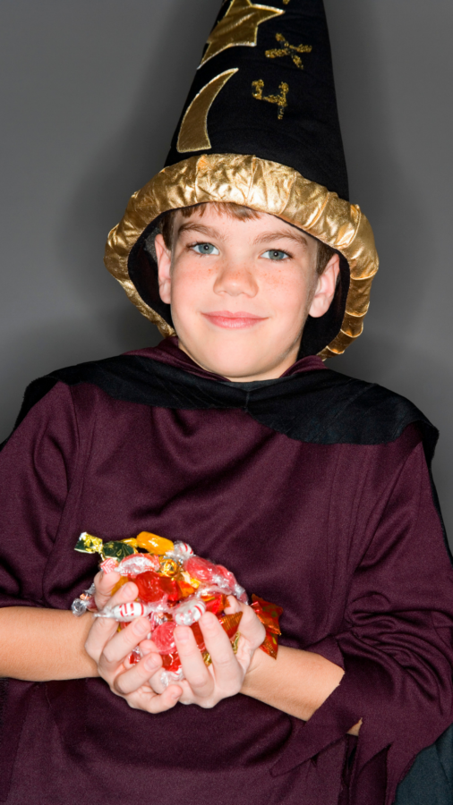 young wizard boy with a handful of Halloween candy to trade in