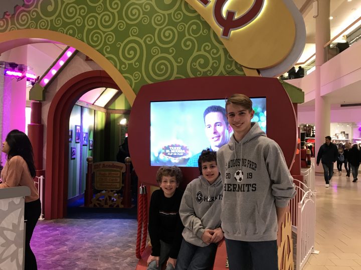 Three boys stand at the entrance to HGTV Santa HQ