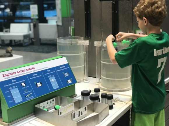 boy in engineering a river exhibit at Boston Museum of Science