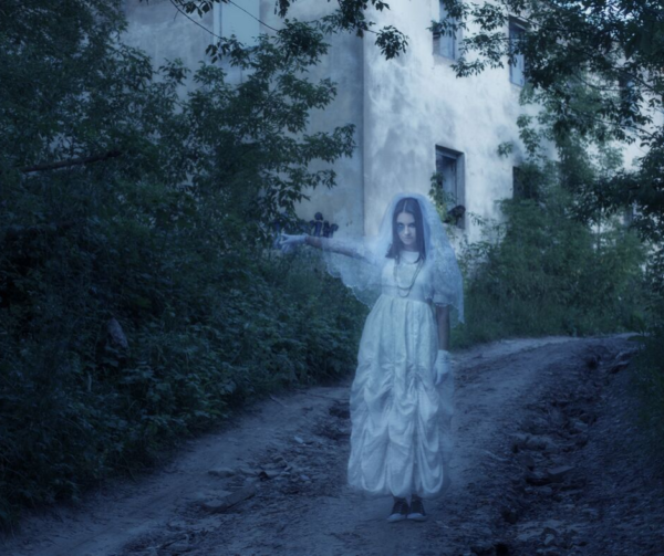 female ghosts walks down a pathway