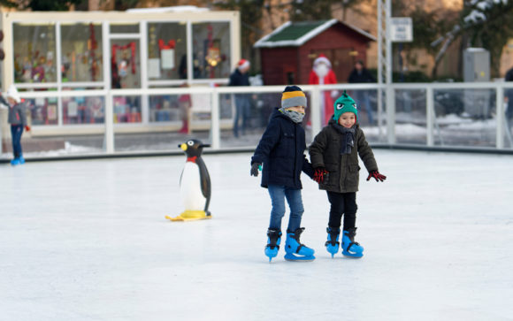 Two children ice skating on ice skating rink