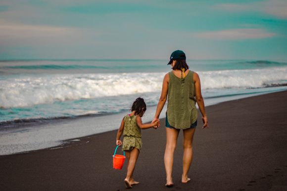 Canva-Back-view-Photo-of-Woman-and-Child-Holding-Hands-While-Walking-on-Beach