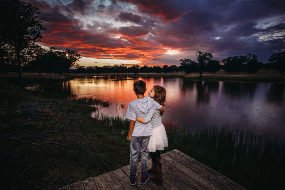 Kids on a pier watching the sunset.