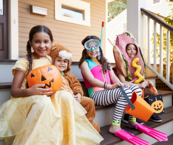 North Jersey Trick or Treat Times A group of kids in Halloween costumes sit on stairs waiting for New Jersey trick or treating to start