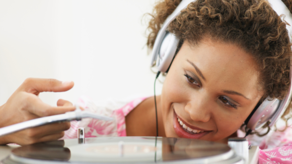 black female with headphones plays records