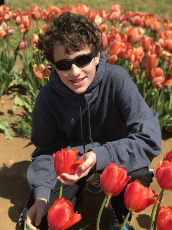 Male teen poses with tulips in NJ.