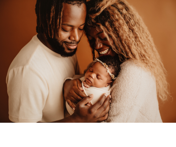 A black mother and father pose with their newborn. Dad is ready to support mom with her changes after pregnancy.