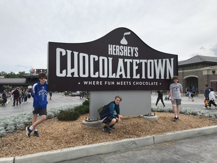 family picture in front of Hershey's Chocolatetown sign