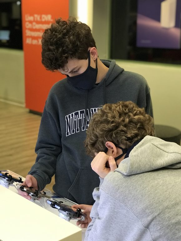 2 Teens look over iphones available as part of the Black Friday Xfinity Mobile Deals