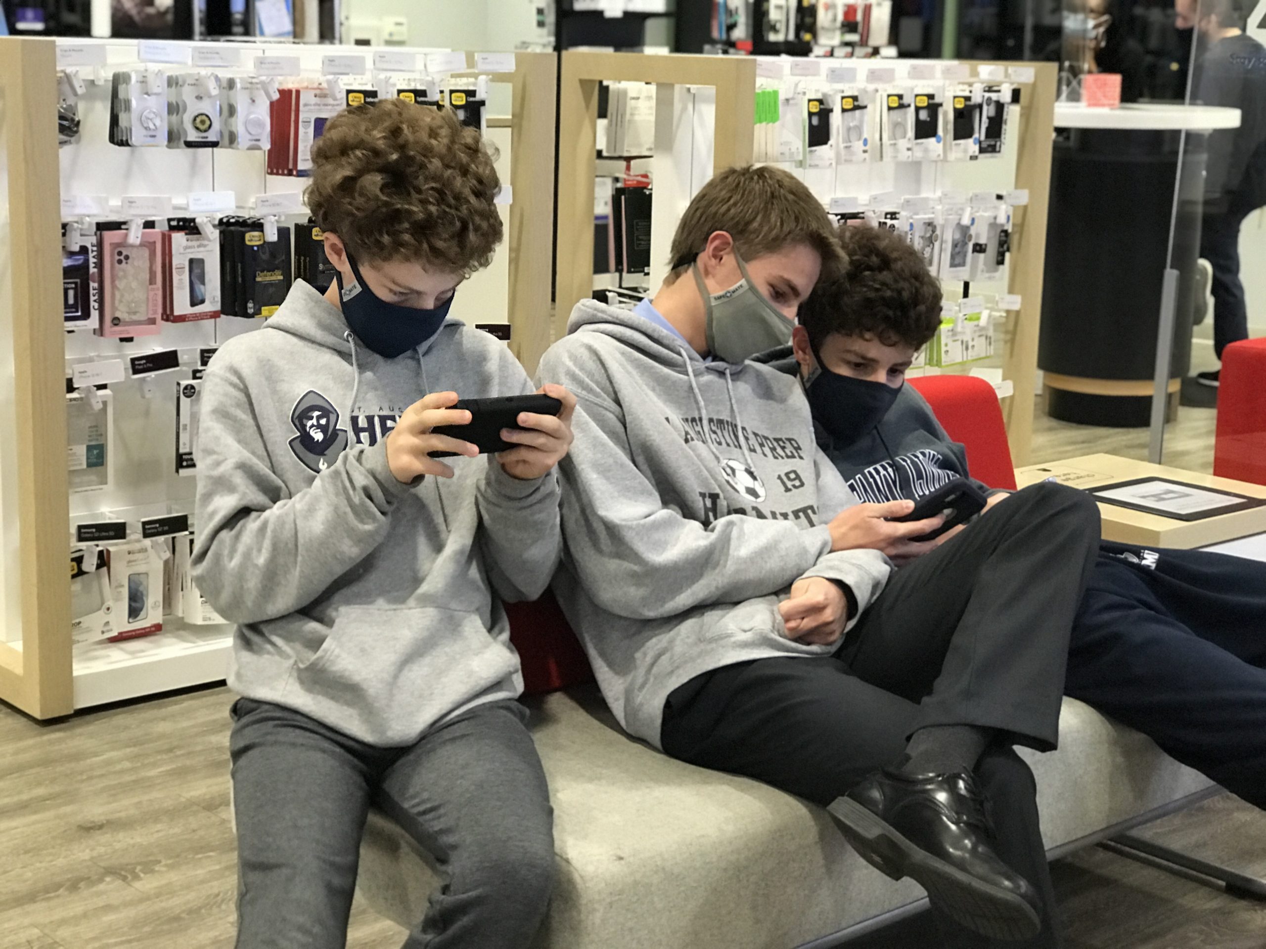 3 teens on their iphones at Mays Landing Xfinity store