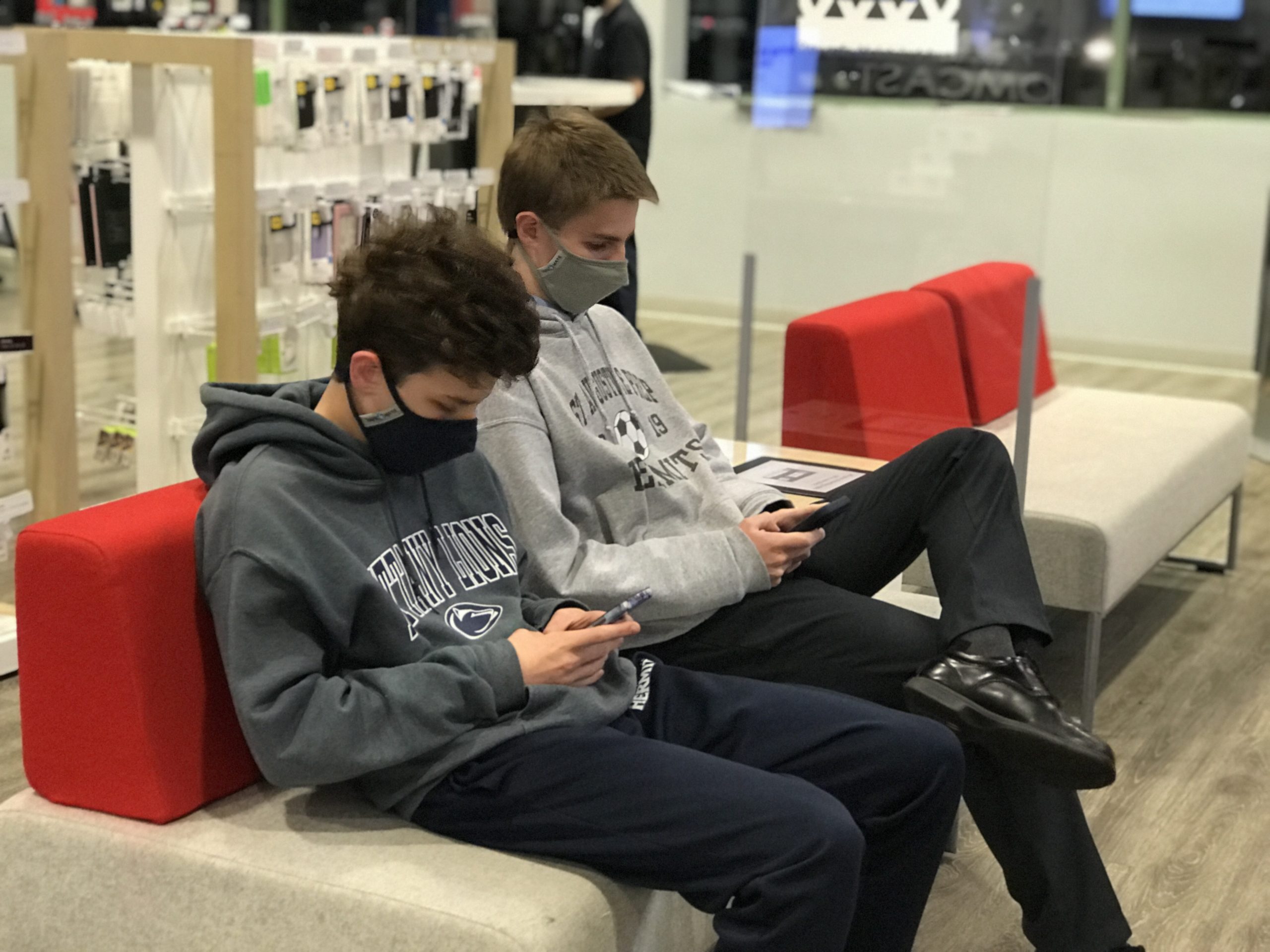 2 Teens look over iphones available as part of the Black Friday Xfinity Mobile Deals
