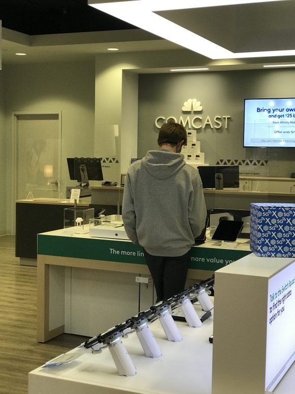 Teen boy looks over ipads available at Xfinity stores
