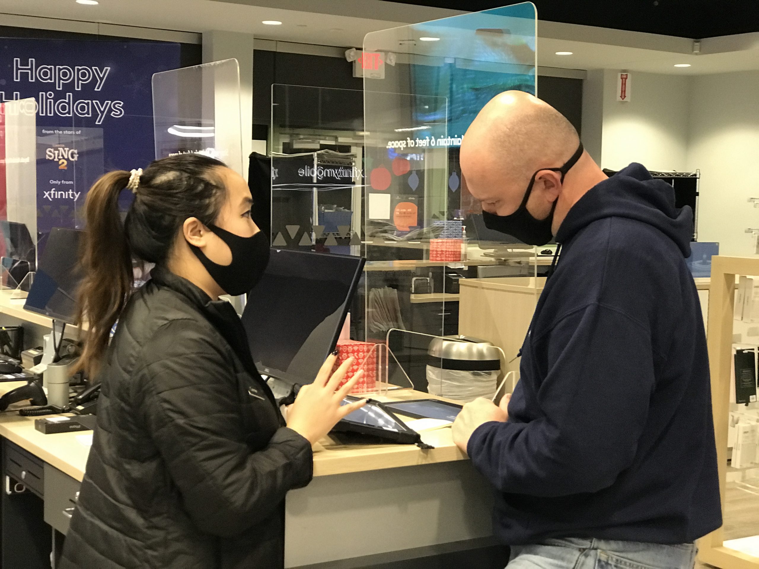 Xfinity Associate Connie in Mays Landing reviews with a customer how much he can save with Xfinity Mobile Black Friday deals