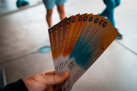 a person's hand holding museum tickets