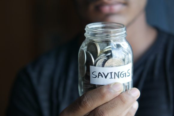 image of person holding a jar with coins labeled savings