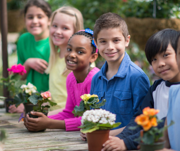 children plant flowers for a community garden