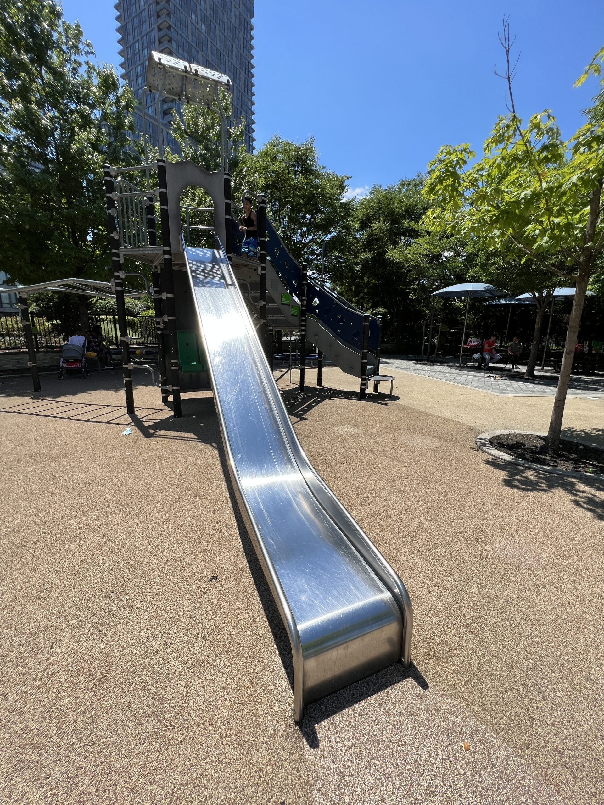SLIDE - long straight metal slide at climbing wall tower AT Newport Green Park Playground in Jersey City NJ