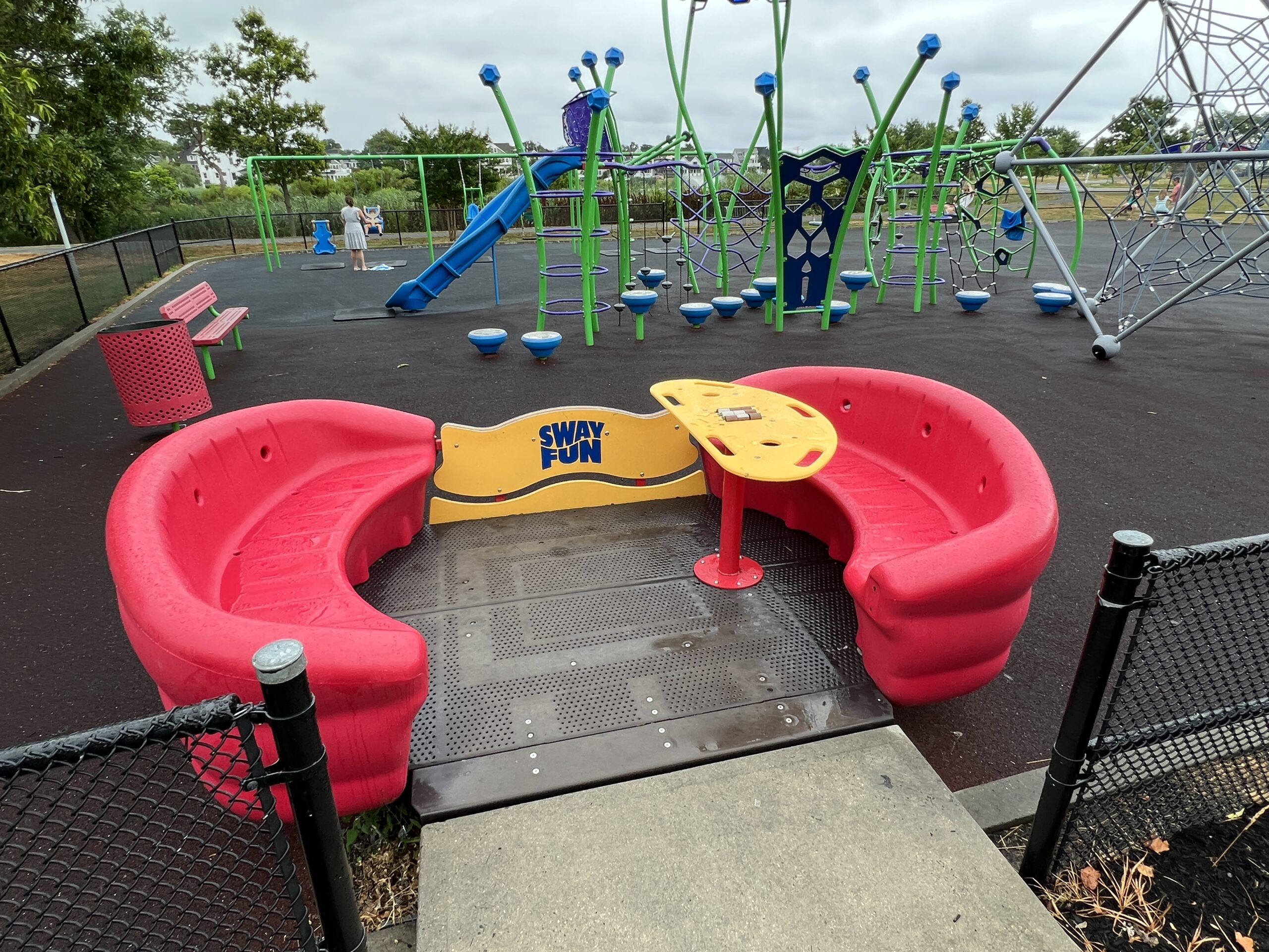 Accessible - Sway fun Glider with playground behind WIDE image street side (best) at Jane Magovern's Playground in Belmar NJ