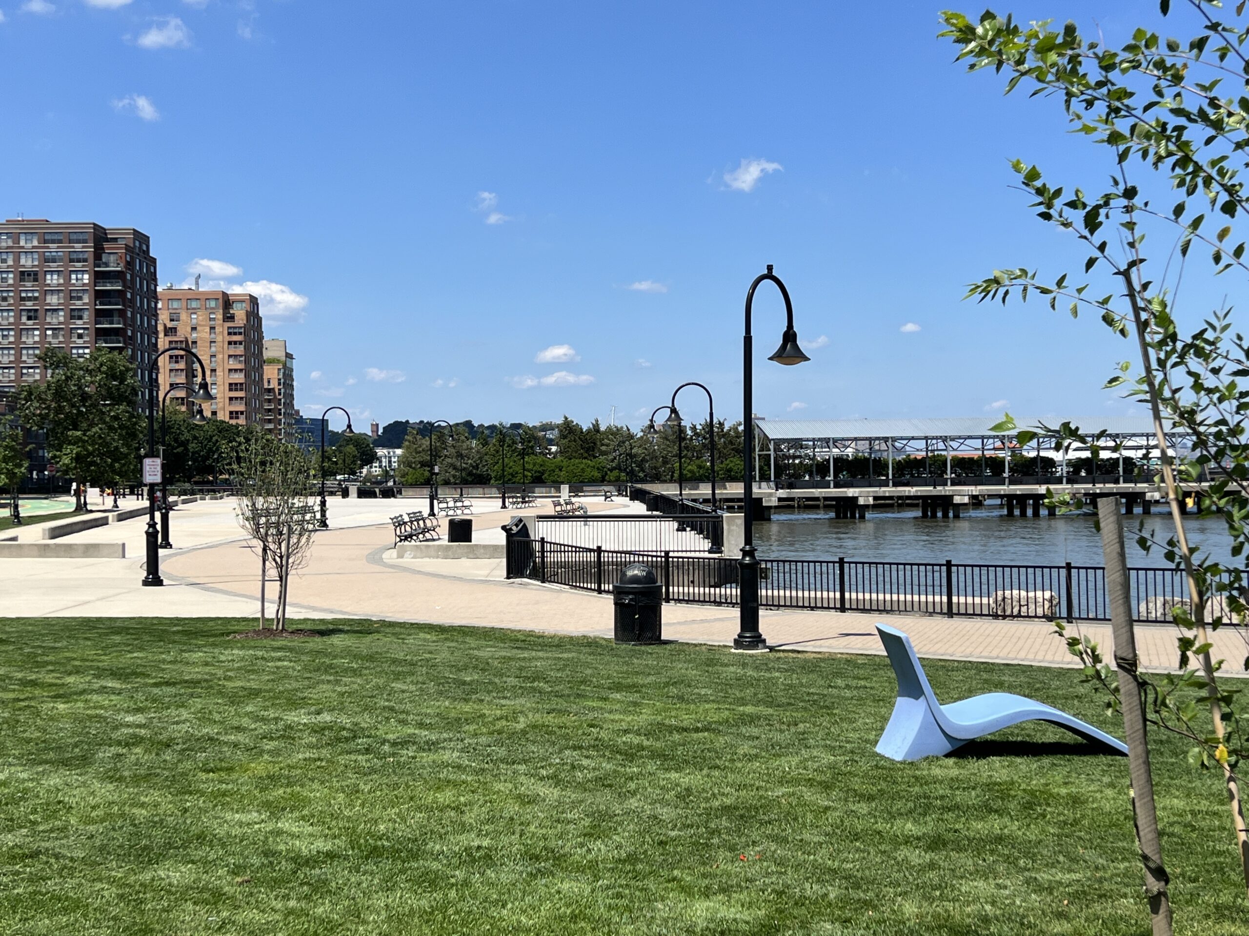 Maxwell Place Park in Hoboken NJ - Lounge chair in grassy area with waterfront view WIDE image