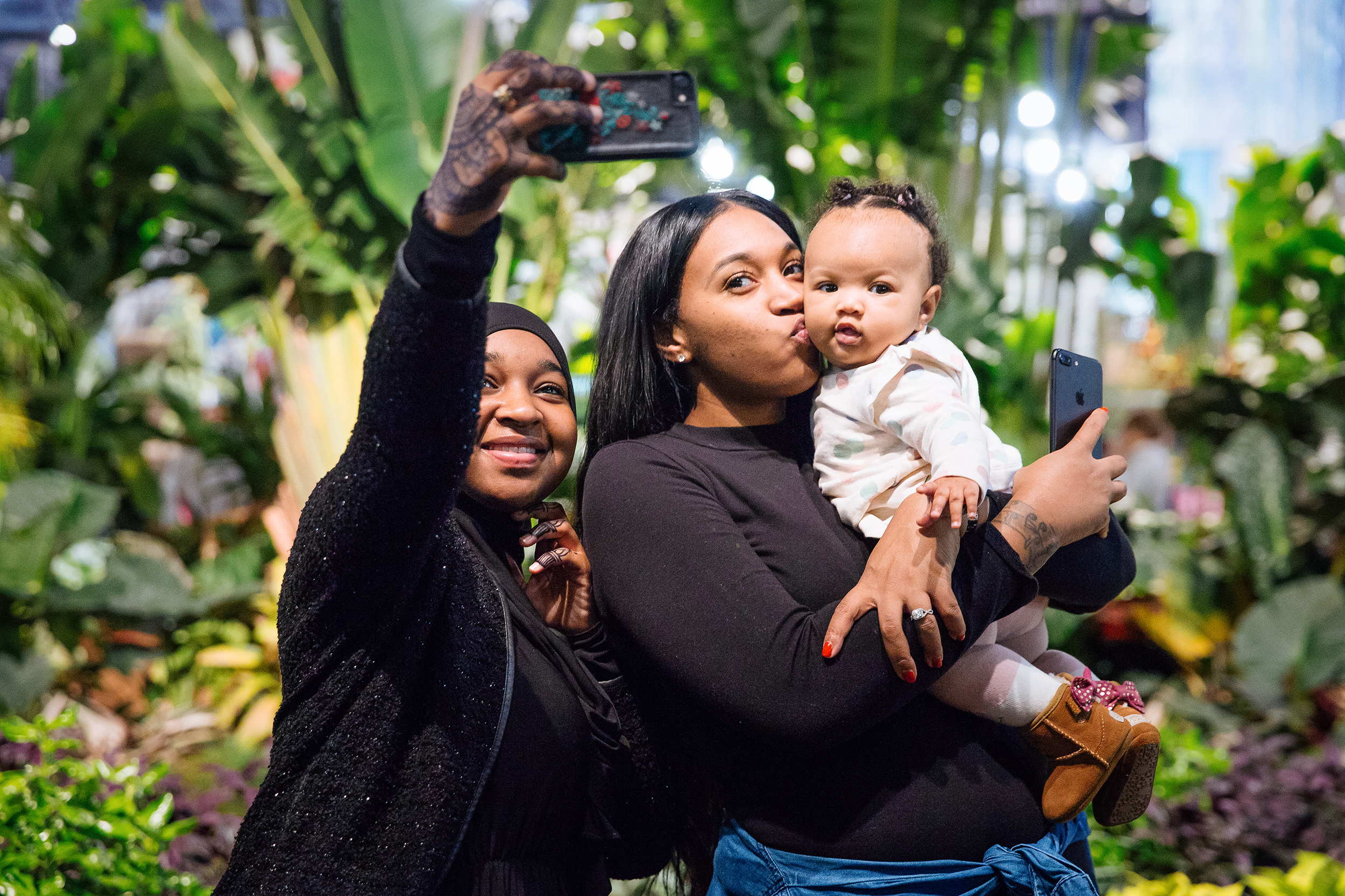 A family takes selfies at Philadelphia Flower Show 2023