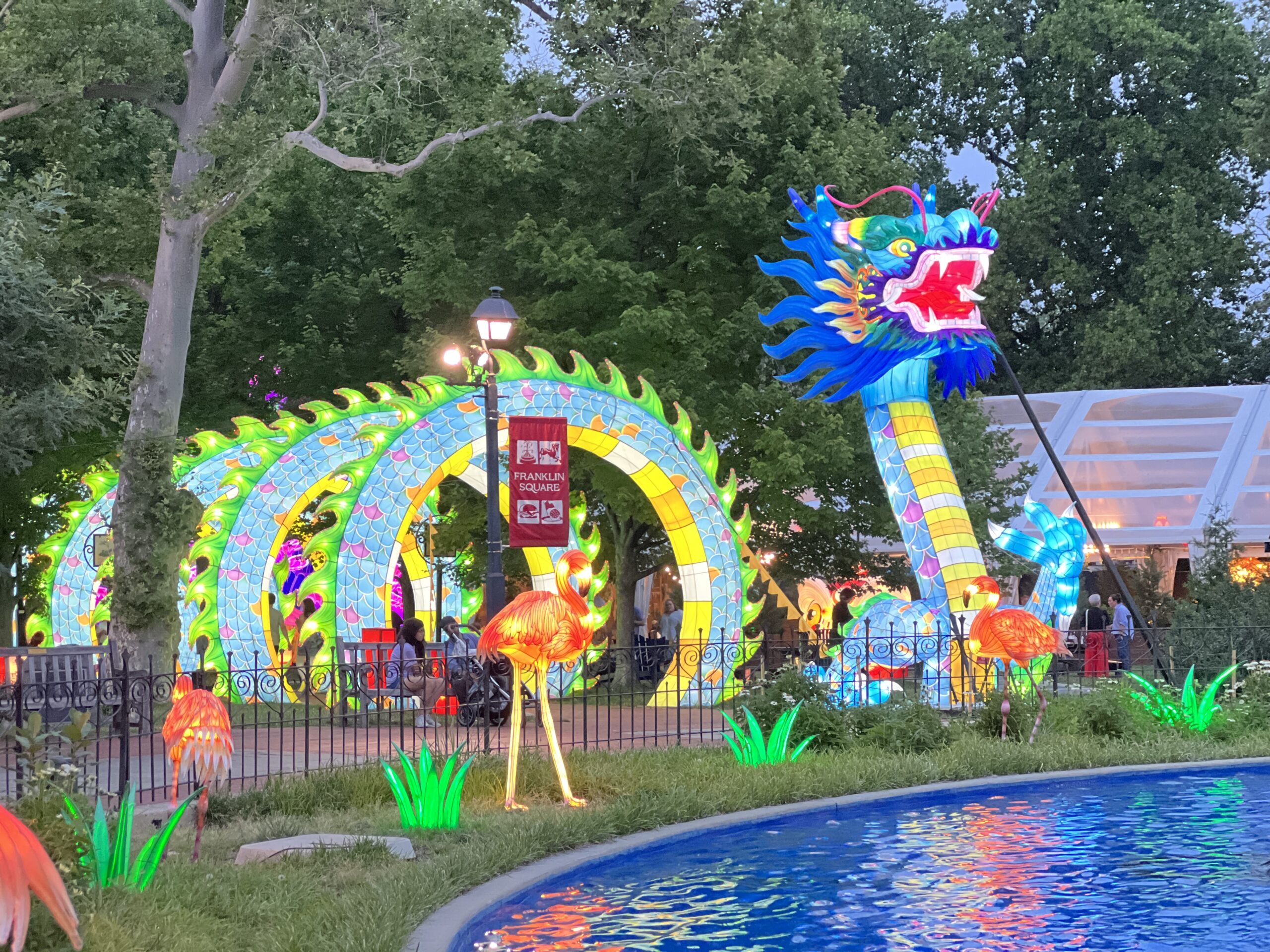Rendell Family Fountain with Sea Dragon Tunnel and flamingos at Philadelphia Chinese Lantern Festival at dusk WIDE
