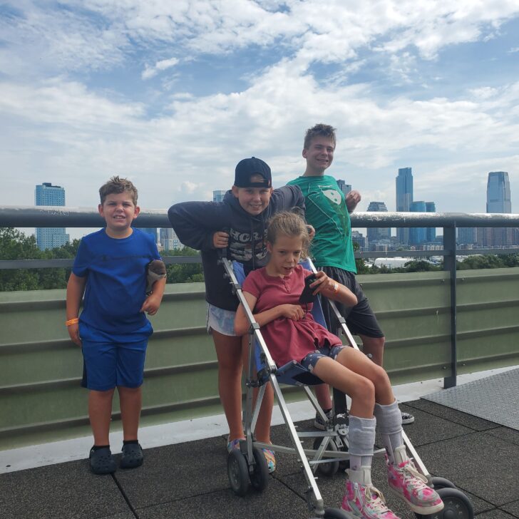 Family picture on Liberty Science Center Balcony overlooking NYC skyline